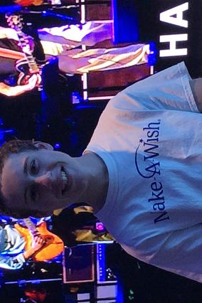 Zach posing in front of the stage at the concert