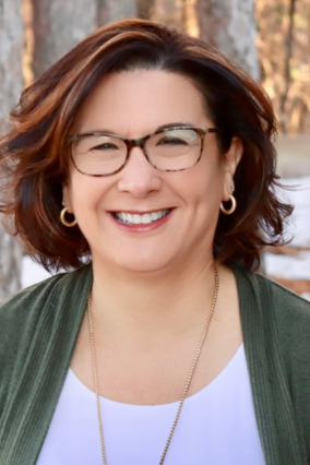 Teresa smiling with glasses and brown hair