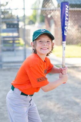 Seton in an orange uniform holding a baseball bat