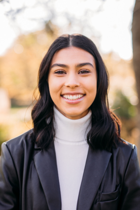 Naiya headshot in a turtle neck with a black jacket.