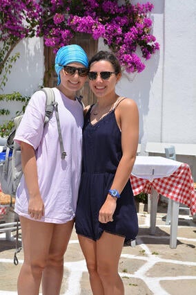 Elizabeth and sister in front of flowers in greece