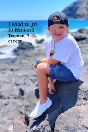 Wish kid Truman sitting on a rock by the ocean
