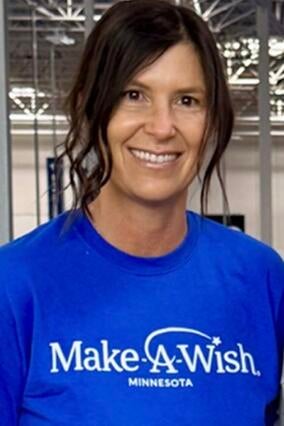 Lise in a blue Make-A-Wish shirt in front of a plain background