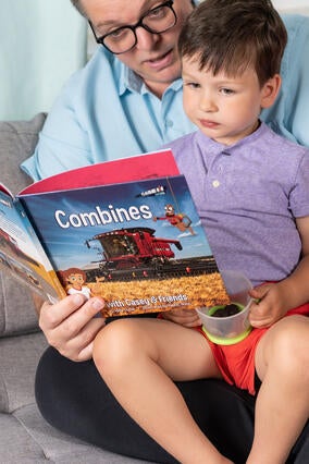 Wish kid Henry reading a book about combines with his dad