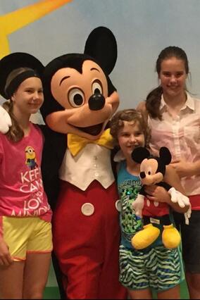 Hannah posing with Mickey Mouse & her siblings
