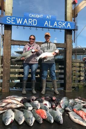 Two people holding fish at Aurora Charters