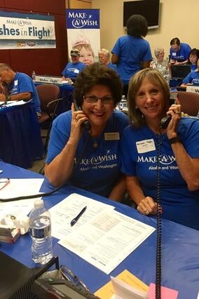 2 volunteers answering the phone at the mileage drive