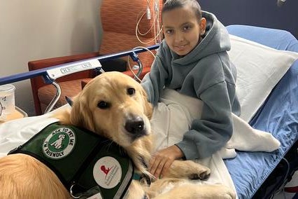 Wish kid Anika with a therapy dog at St. Jude. 
