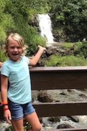 Wish kid Arden in front of a waterfall