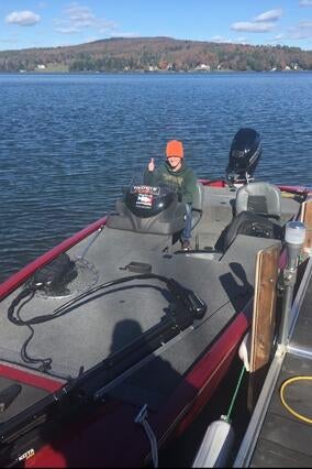 Noah gives a thumbs up from his boat, on the lake