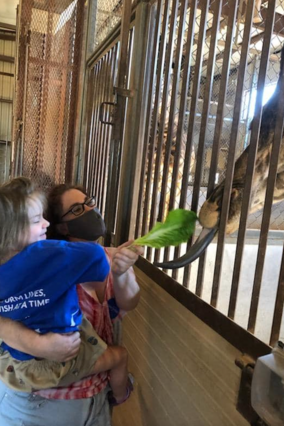 Rhea loved feeding the giraffe.