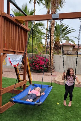 Olivia and her sister playing on the swings