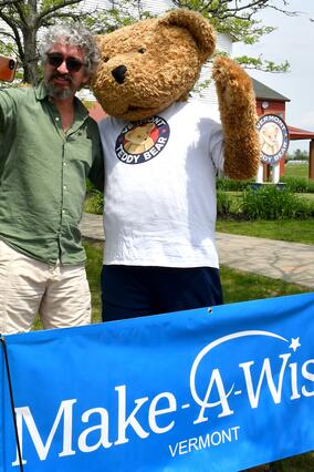 man takes selfie with giant teddy bear mascot