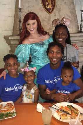 Taylor and her family sitting at dinner with princess Ariel.