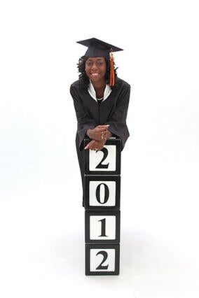 Jakeina wearing a capt and gown for her high school graduation with 2012