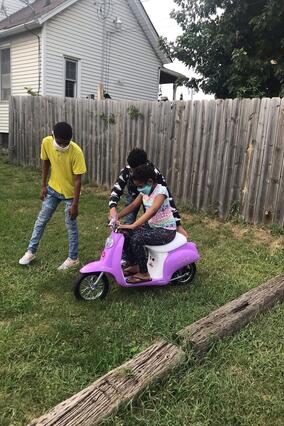 Miracle rides her scooter she received during her shopping spree.