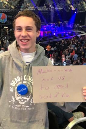 Zach posing in front of the stage on his wish trip