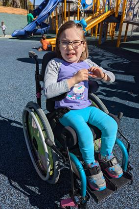 Marcy in her wheelchair playing on an adaptive playground