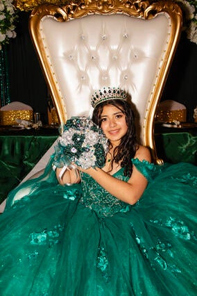 Emely seated on her white throne showing her bouquet
