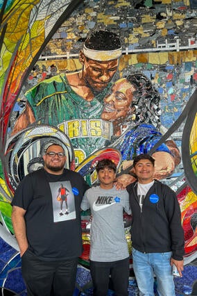 Derek with family in front of mural