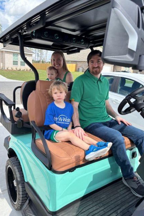 Conrad and his family in the golf cart