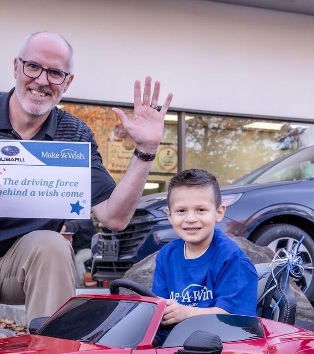 Wish kid in front of Subaru dealership