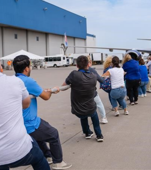 People pulling a plane with a rope.