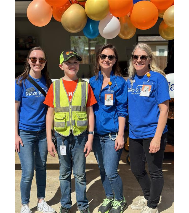 Three volunteers standing with a wish kid