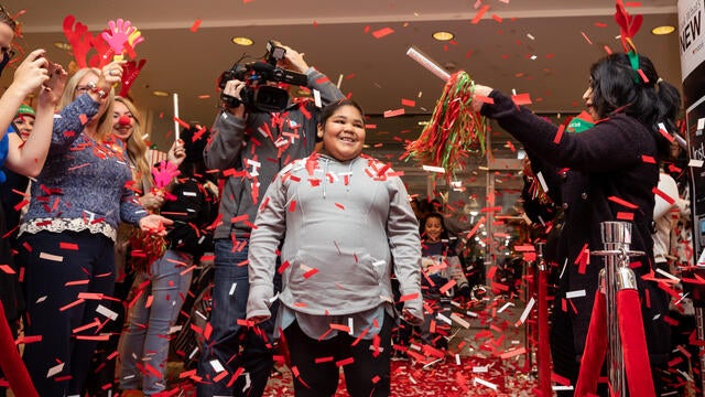 Glenda smiles as confetti falls at Macy's