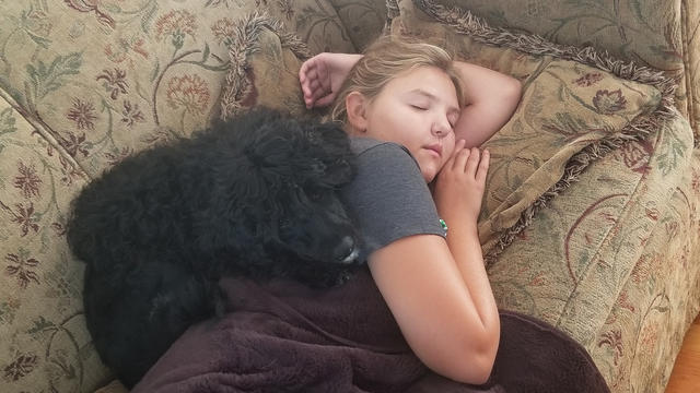Diane snuggles with her puppy, Rosie, on the couch