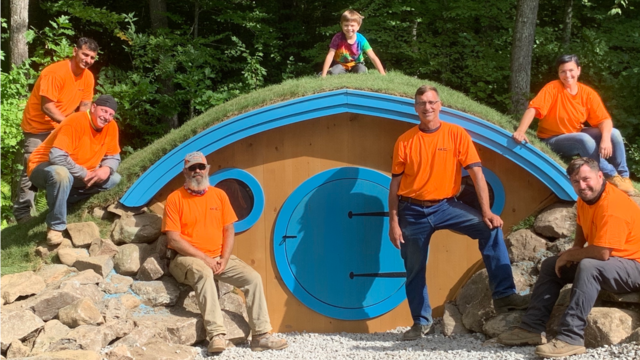 Wish child Drew on the roof of his Hobbit Hole surrounded by the crew from Calvalieri Construction who helped install the Hobbit Hole.