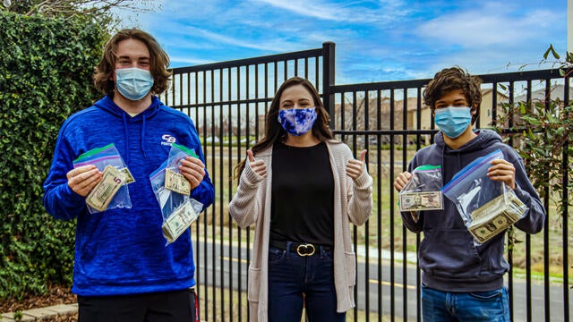 Jacob and Jacob pictured with a Make-A-Wish staff member dropping off the cash and check donations that they earned during their fundraiser