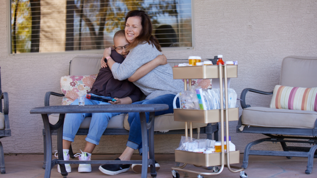 Wish kid Kylie and mom hugging on porch