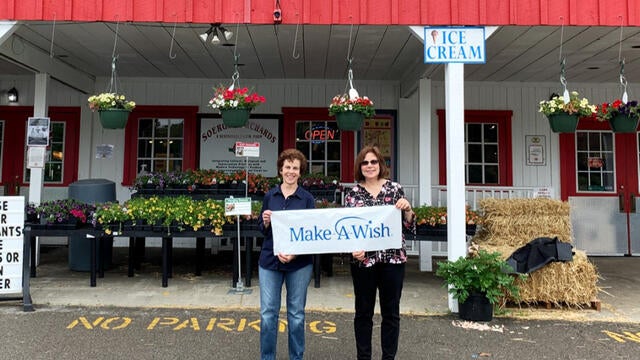 Kate Buckley presents a donation to Stephanie Pugliese in front of Soergels Orchard.