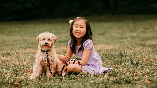 Maelin- Kate smiles while sitting next to her new puppy, Penny.