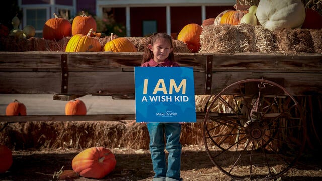 Annie holding her "I am a wish kid" sign for all to see.
