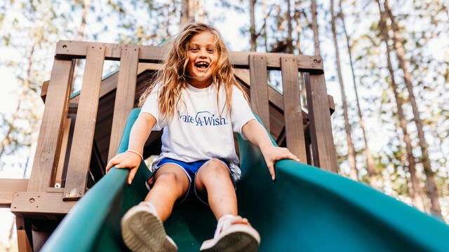 Caroline slides down with a huge smile