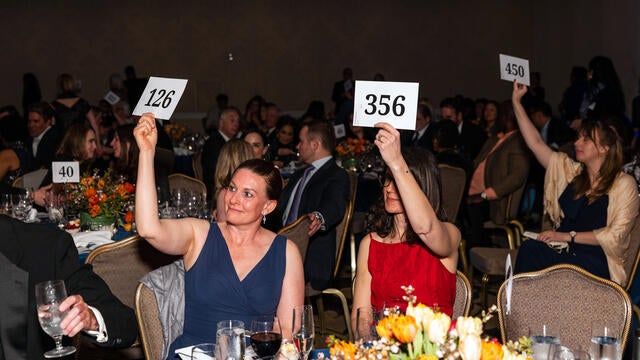 Guests raise paddles during Adopt-A-Wish at gala