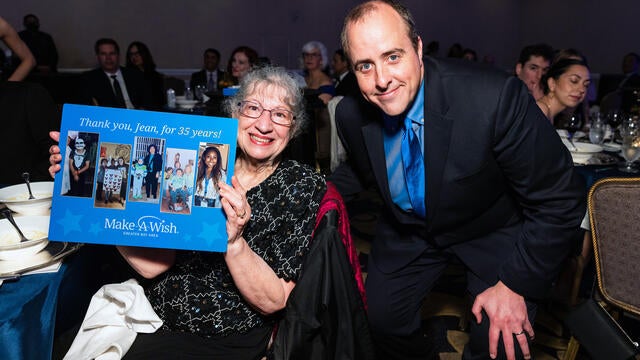 Jean Ingraffia-Delosreyes holds up a milestone volunteer plaque, Daniel Marlay to her right
