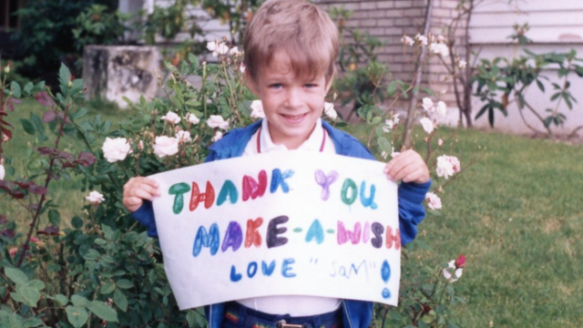 Sam holds a thank you sign