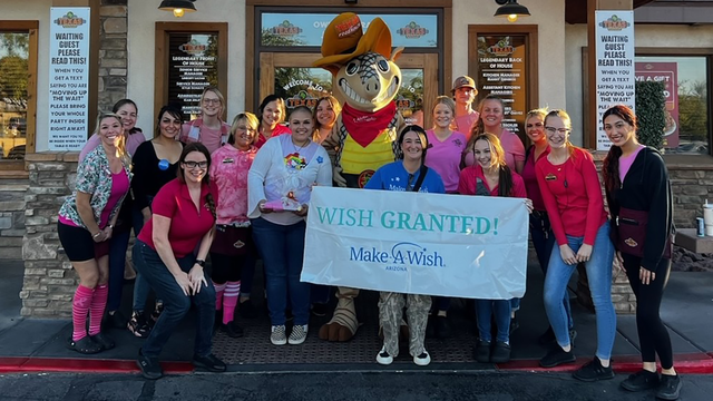 Laxy stands with her wish team to celebrate her wish to shop for makeup and clothes.
