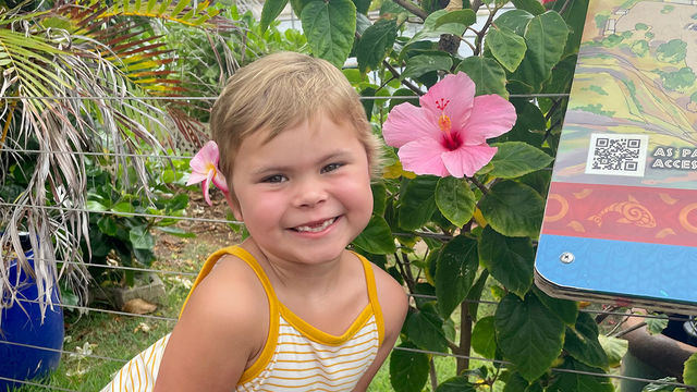Charlotte poses with a flower in her hair during her wish to visit the island of Hawaii.