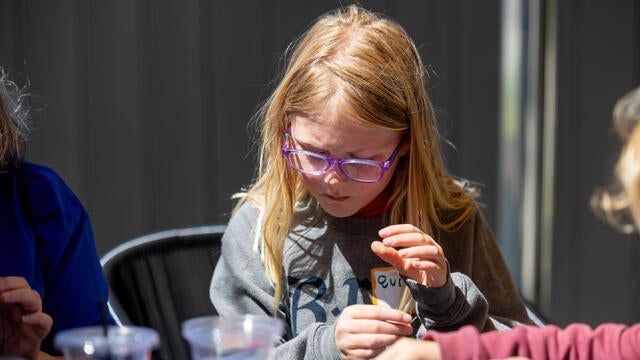 Wish kid Quinn adds a personal touch to her handmade bracelet.