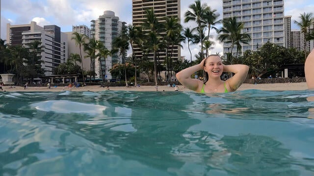 Wish Kid Mercy in the Ocean with Hotels in the Background