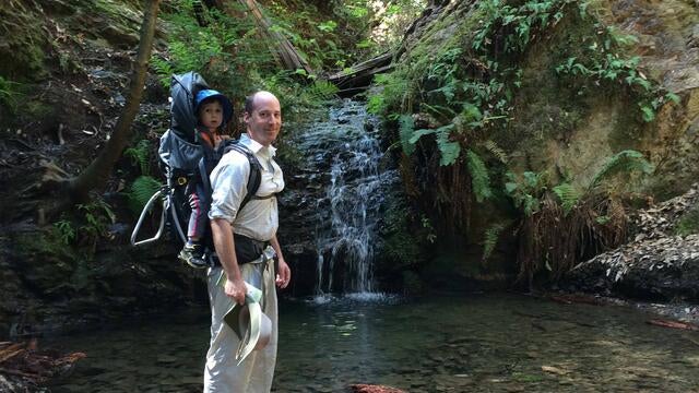 Rhydian, age two, riding on his dad Bradley's back, experiencing his first waterfall in 2015.