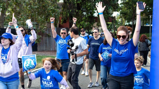 Walkers celebrate crossing the finish line at 2024 Walk for Wishes