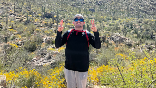 Jose Cazares, April volunteer of the month, standing in Arizona desert