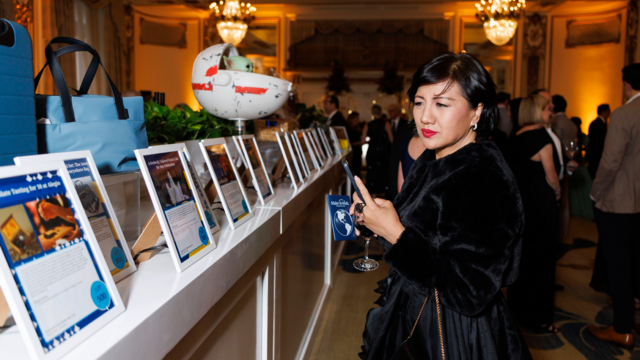 Passport in hand, Liz Pham peruses the silent auction. 