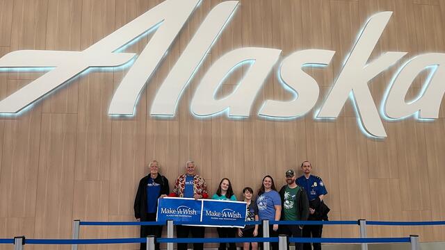 Wish family in front of Alaska airlines sign 
