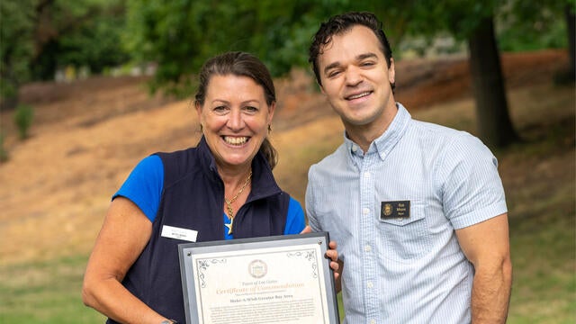 CEO Betsy Biern holds a plaque of commendation next to Mayor Rob Moore